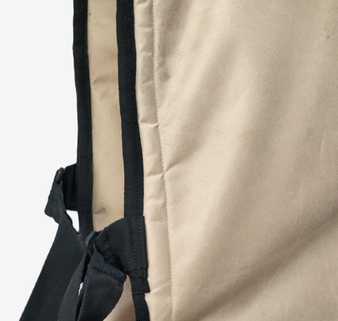 Close-up of beige fabric waveski cover with black straps on a white background